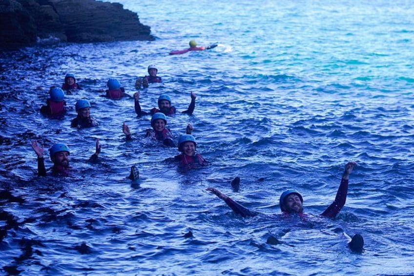 Folk svømmer i havet, nogle bærer hjelme. 2