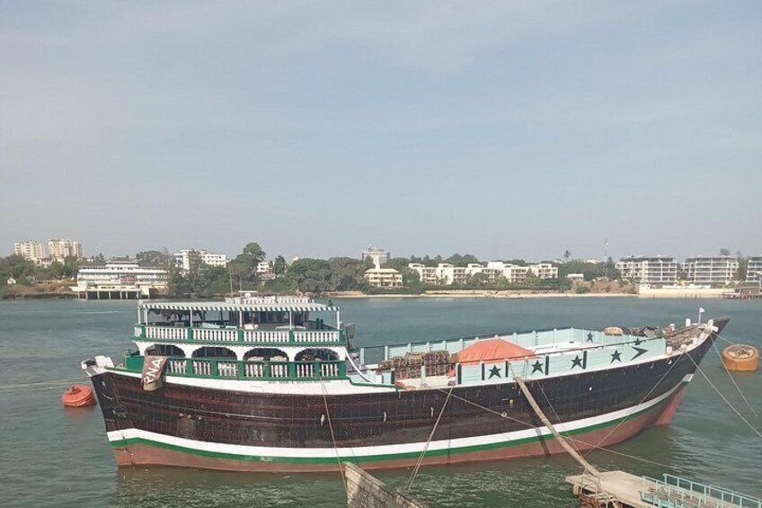 Un barco grande amarrado en un muelle con un horizonte urbano de fondo. 3