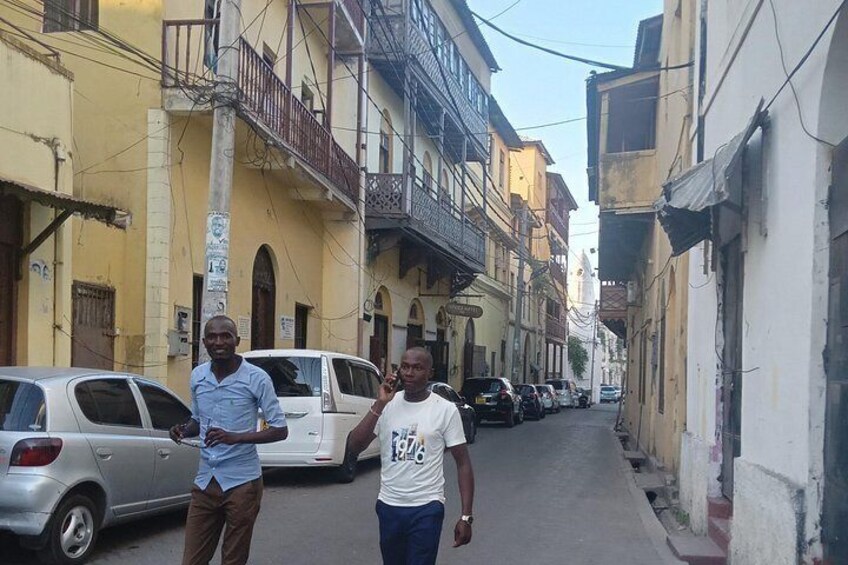 Una calle estrecha con coches aparcados y edificios con balcones. 5