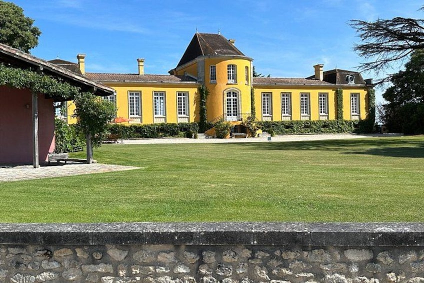 Un edificio giallo con un muro in pietra in primo piano. 4