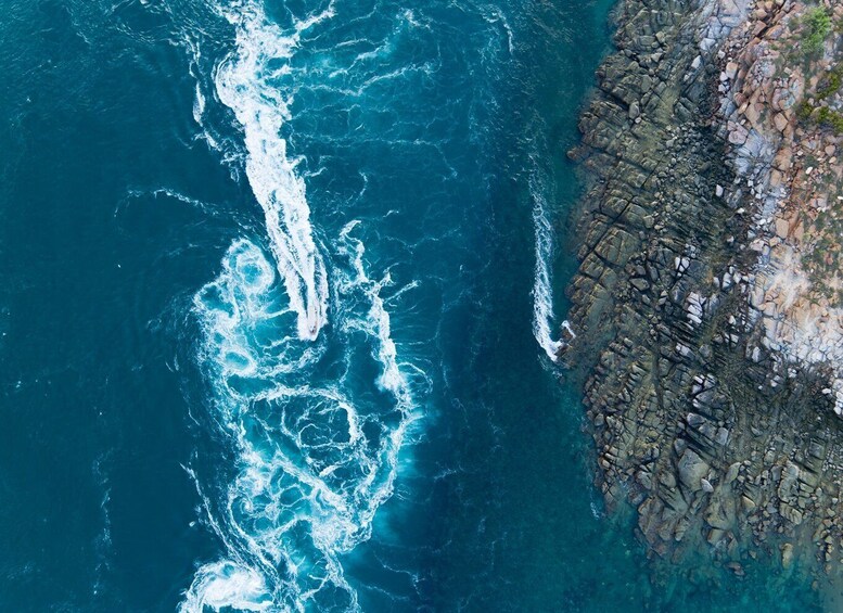 A coastal area with turbulent ocean waves crashing against a rocky shoreline. 2