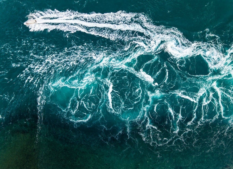 A white boat creating a wake in the ocean. 3