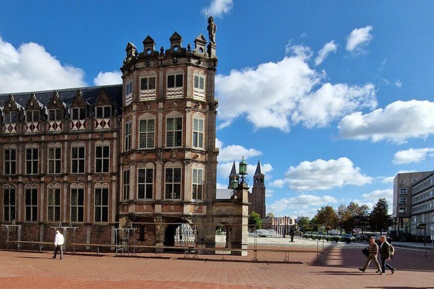 A historic building with a turret and a statue in front. 5
