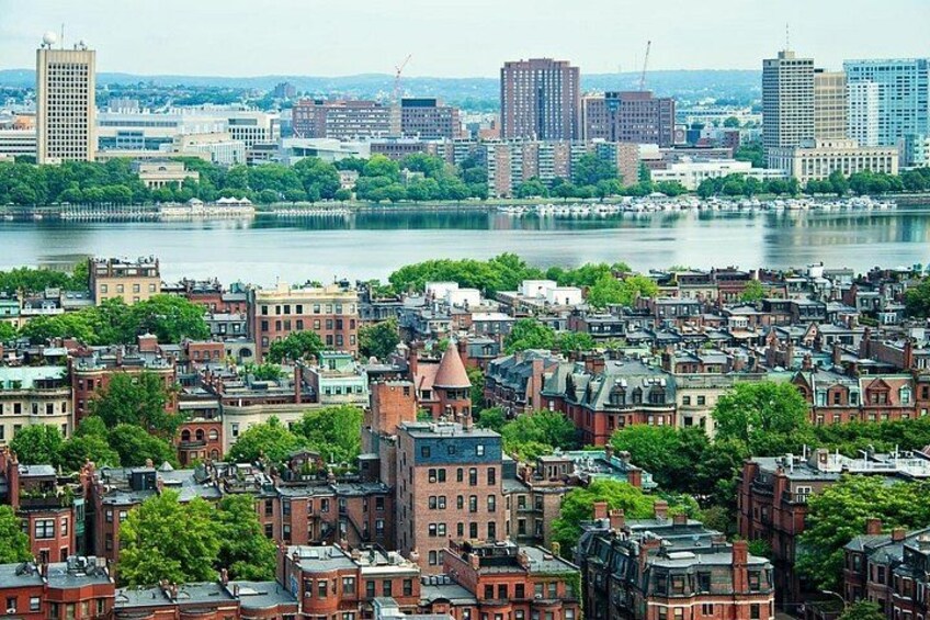 A cityscape with dense urban buildings, a river, and a distant skyline. 1
