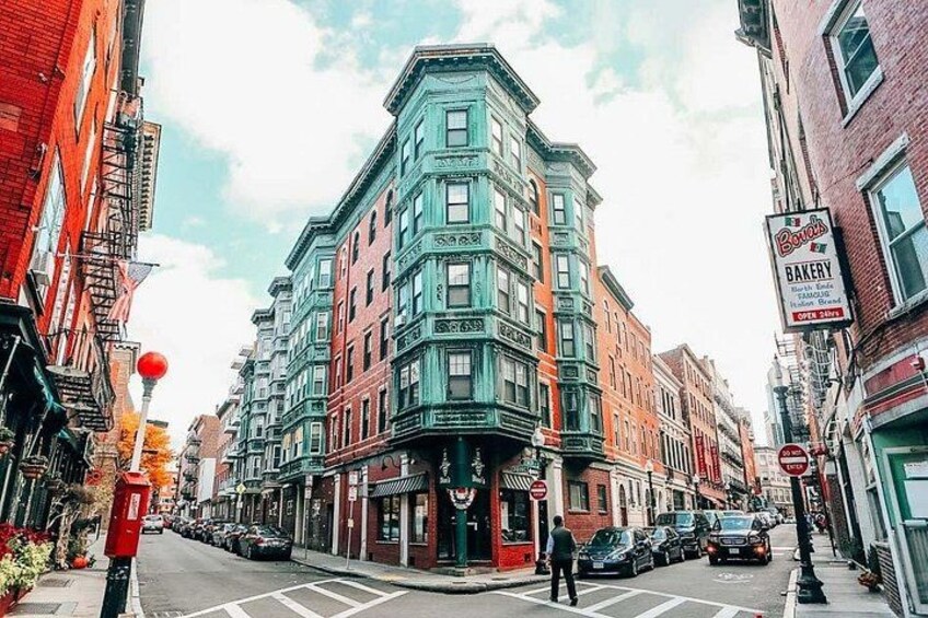 A street lined with multi-story buildings, a bakery sign, and a red mailbox. 4