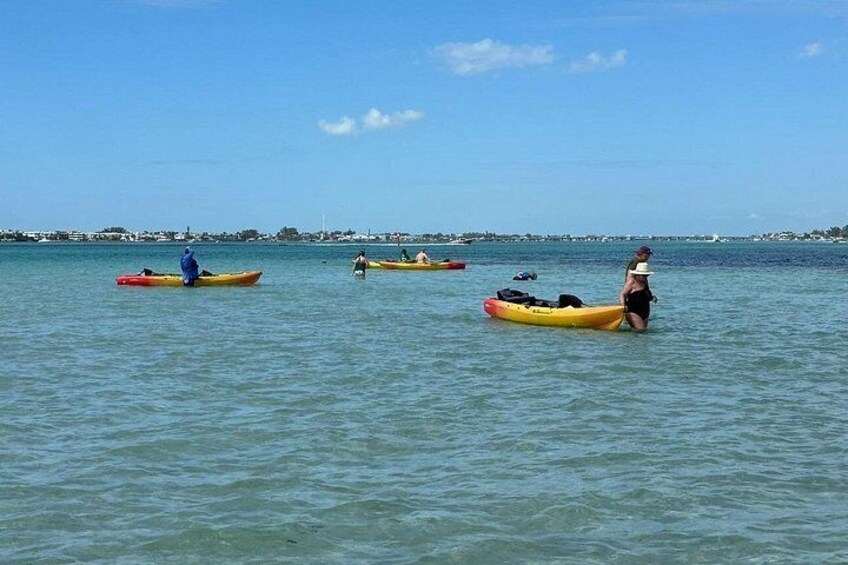 People in kayaks on calm water with a clear sky. 4