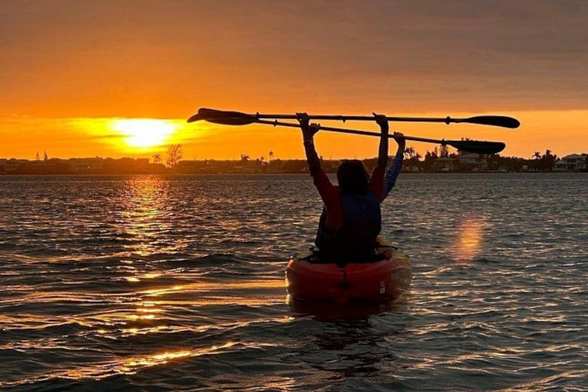 A person kayaking at sunset with a sunset in the background. 2