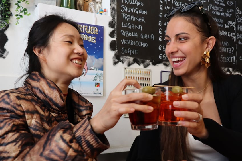 Twee personen houden drankjes vast, met een menukaart op de achtergrond. 3