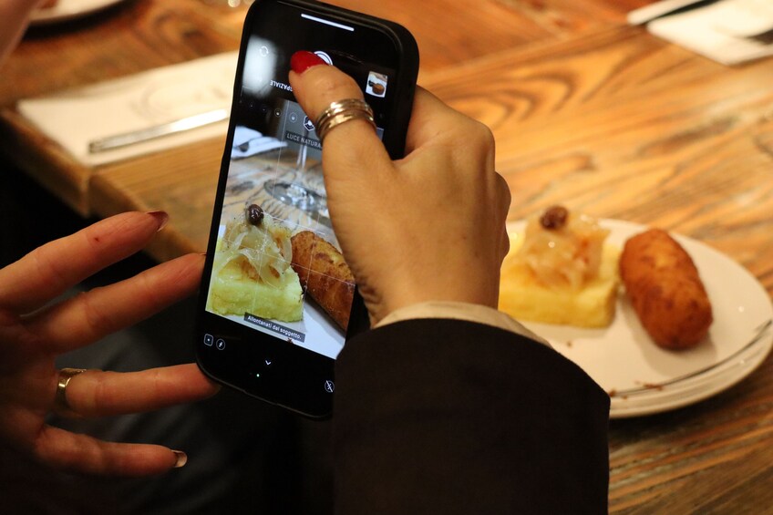A person holding a smartphone displaying a food item. 4