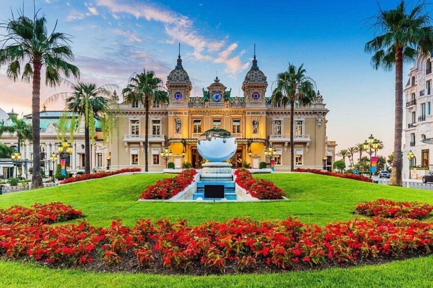 A grand building with domes, a fountain, and well-manicured gardens. 3