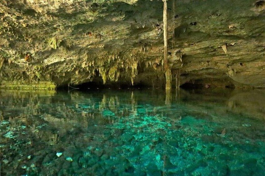 A cave with clear water and stalactites. 4
