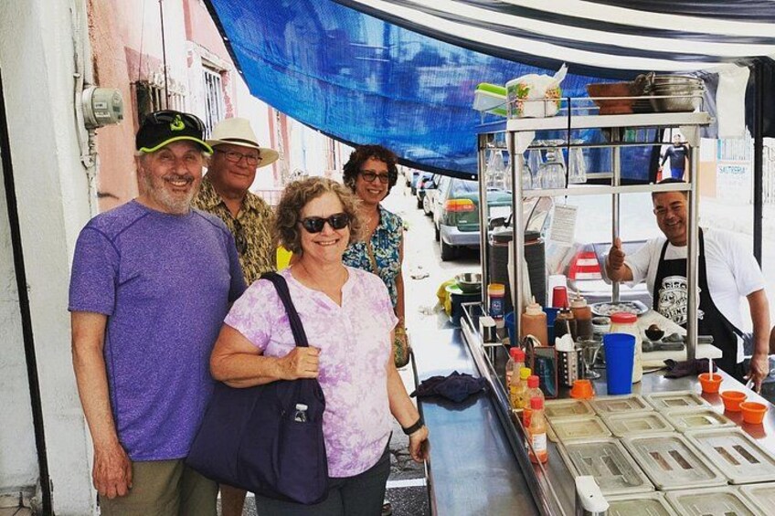 Un vendedor de comida callejera con diferentes salsas y utensilios de cocina. 2