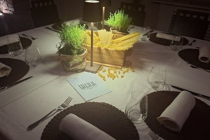 Une table dressée pour un repas, avec une bougie, une plante et une boîte de pâtes. 5