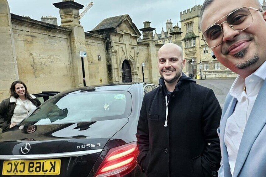 Tre personer står framför en svart Mercedes-Benz SLS AMG med en gul registreringsskylt. 2