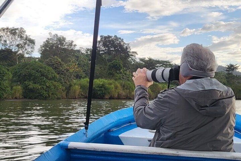 A person in a boat using a camera. 1
