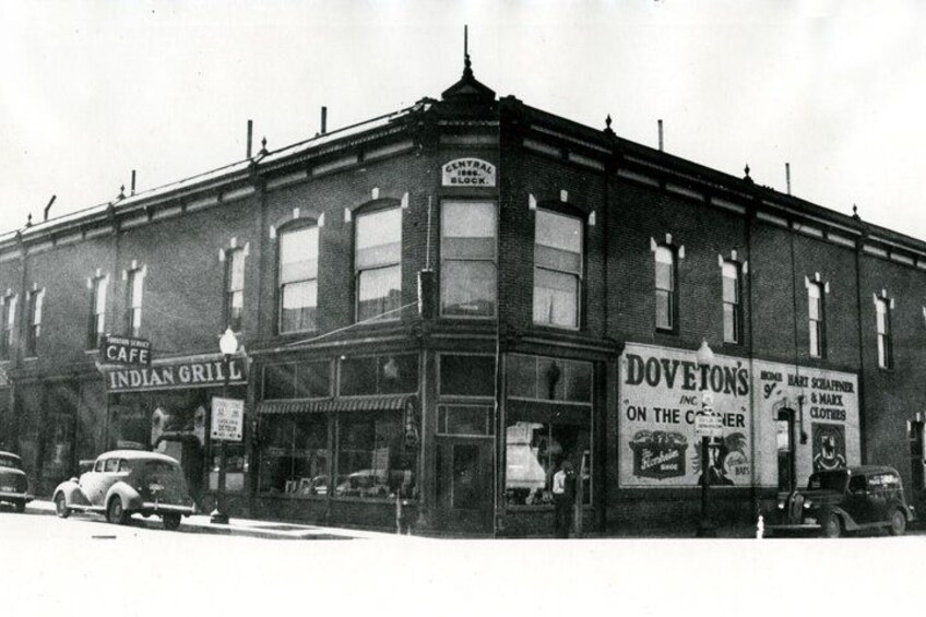 A two-story brick building with signs for 'Cafe Indian Grill' and 'Doveton's On the Corner.' 3