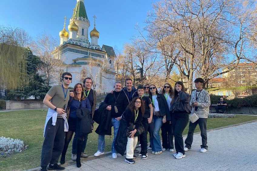 A group of people standing in front of a building with golden domes. 5