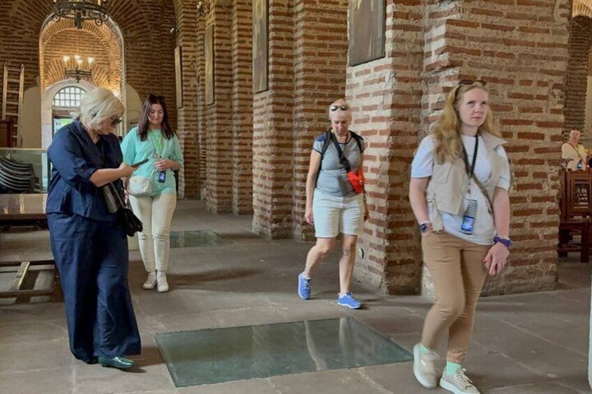 A group of people walking in a historic building with brick walls and arched ceilings. 3