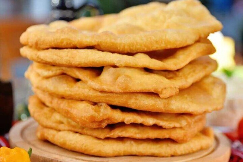 Une pile de beignets dorés et croustillants, disposés sur une planche en bois. 1