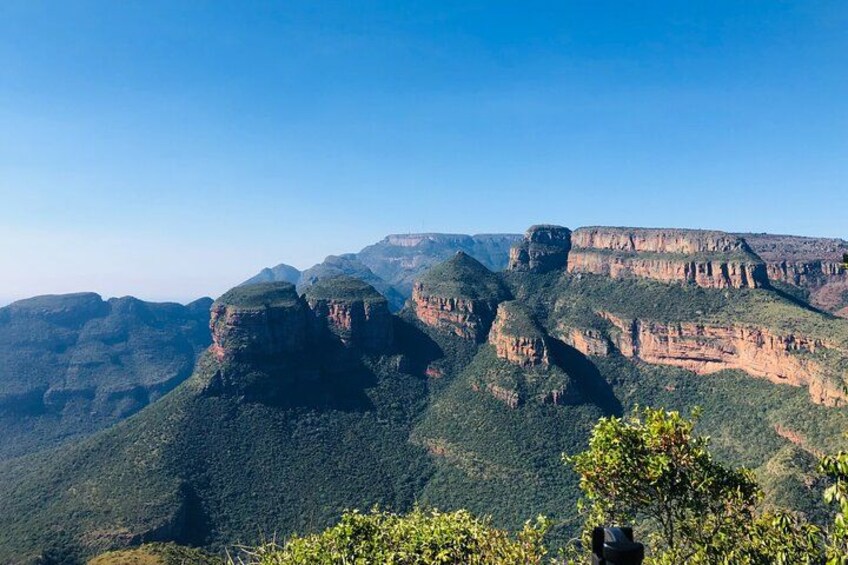 A canyon landscape with steep cliffs and sparse vegetation. 1