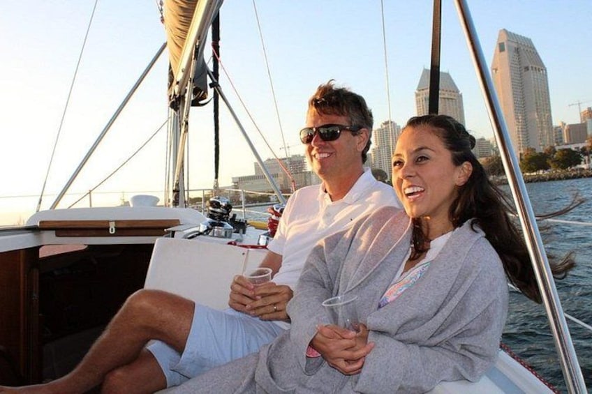 A couple on a sailboat with a city skyline in the background. 5