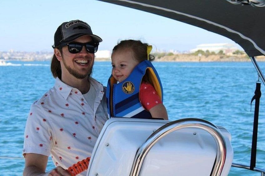 A person in a boat with a child wearing a life jacket. 3