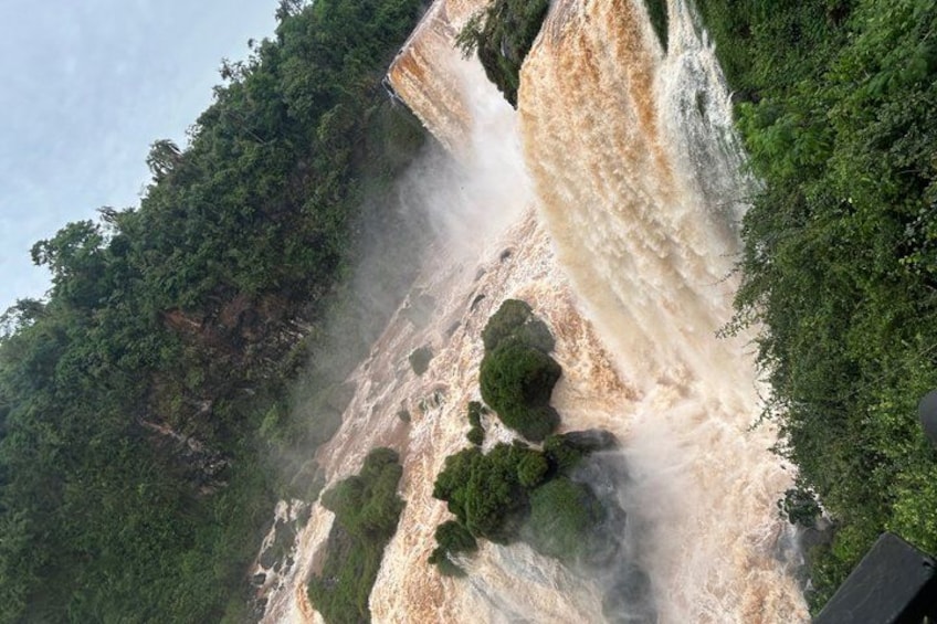 Una cascada se precipita sobre un acantilado rodeado de abundante vegetación verde. 1