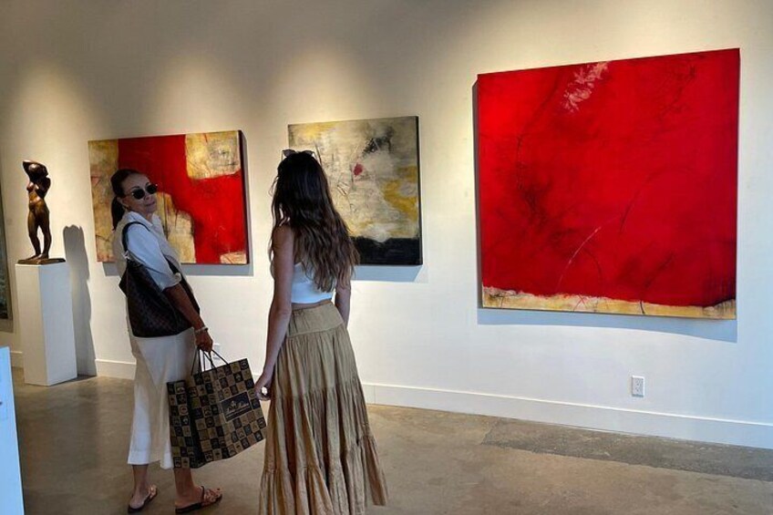 Two people in an art gallery with abstract paintings and sculptures. 5