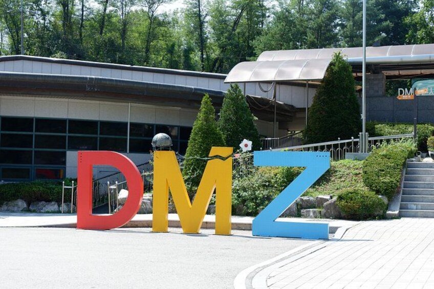 En byggnad med stora bokstäver som bildar ordet ”DMZ”, i färgerna rött, gult och blått. 2