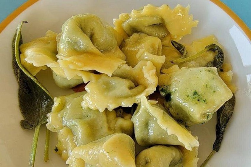 Ein Teller Ravioli mit cremiger Soße und grünen Kräutern. 5