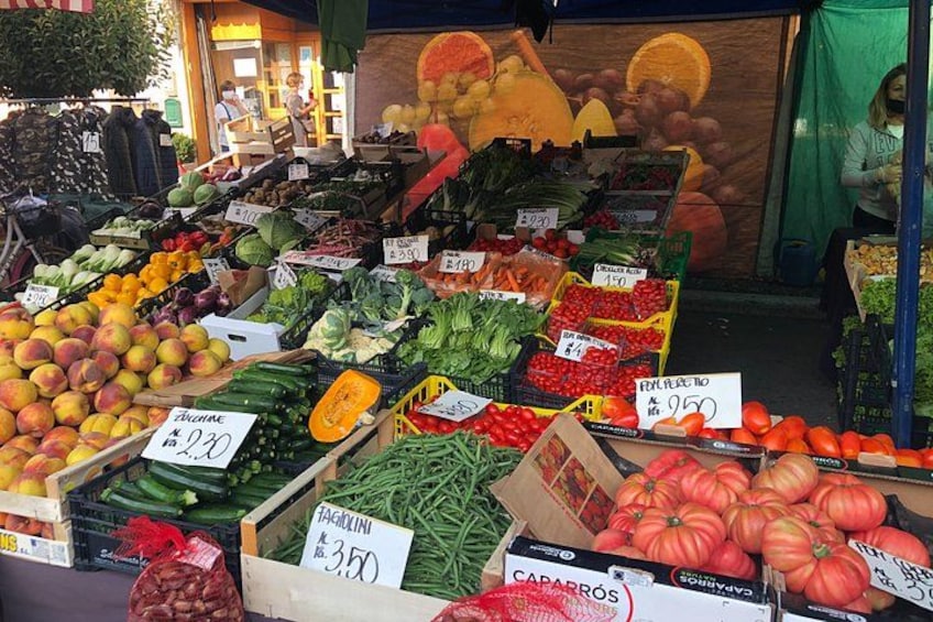 Ein Marktstand mit verschiedenen frischen Produkten, darunter Äpfel, Tomaten und grüne Bohnen. 2