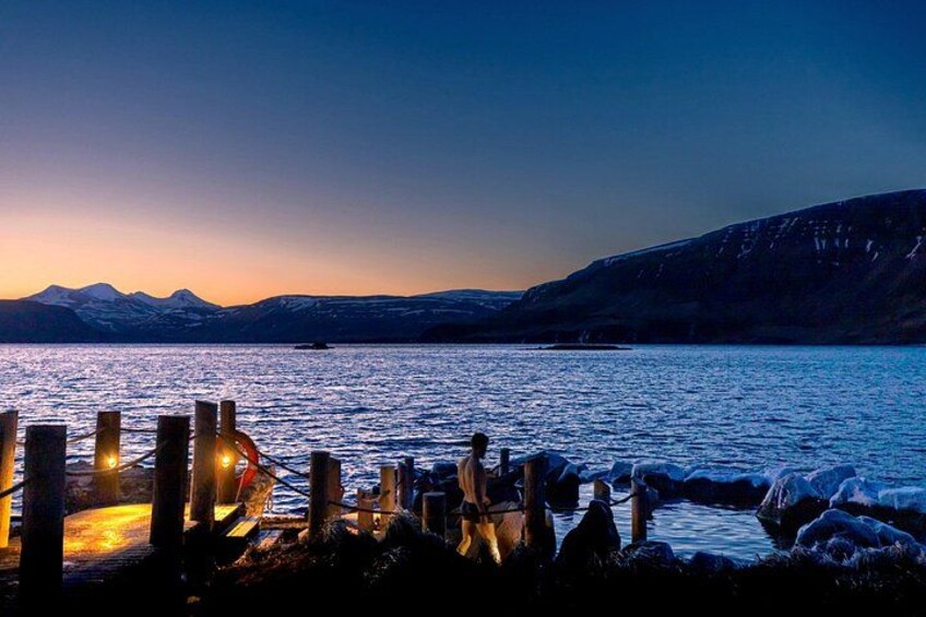 A sunset over a calm lake with mountains in the background and a wooden dock in the foreground. 2