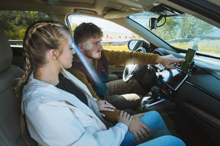 A car interior with a person holding a smartphone. 5