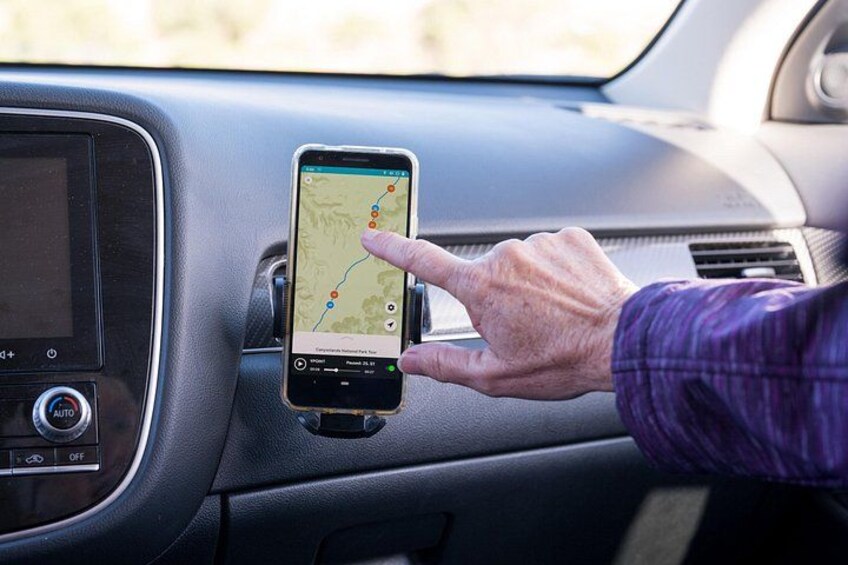 A person using a GPS device mounted on a car's dashboard. 4