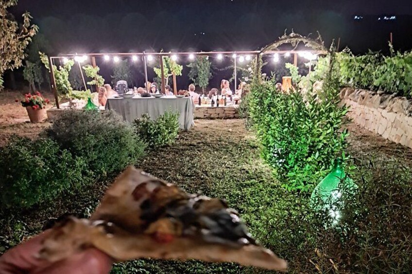 An outdoor dining area with tables and chairs under string lights. 3