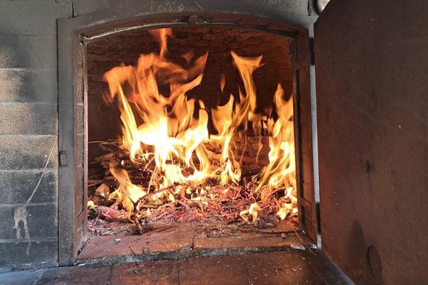 A wood-burning fireplace with flames consuming logs. 5