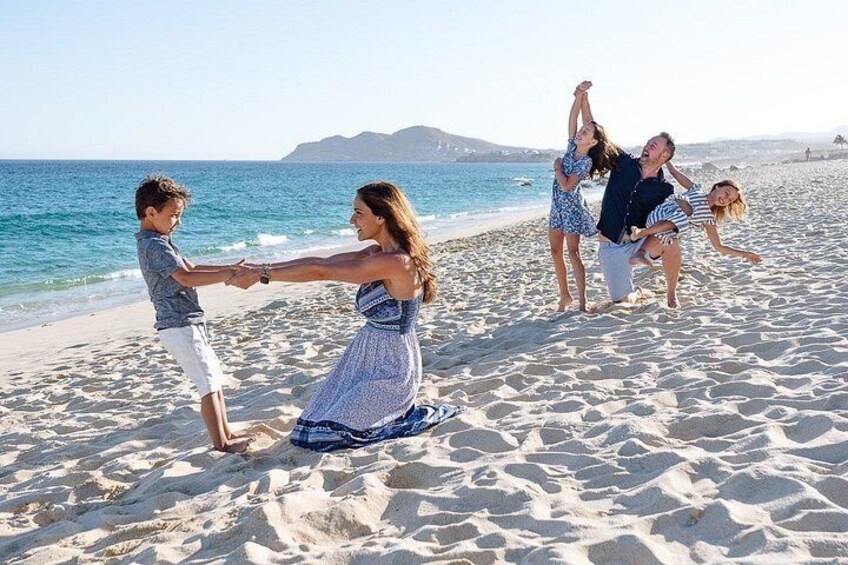 A family on a sandy beach with the ocean in the background. 4