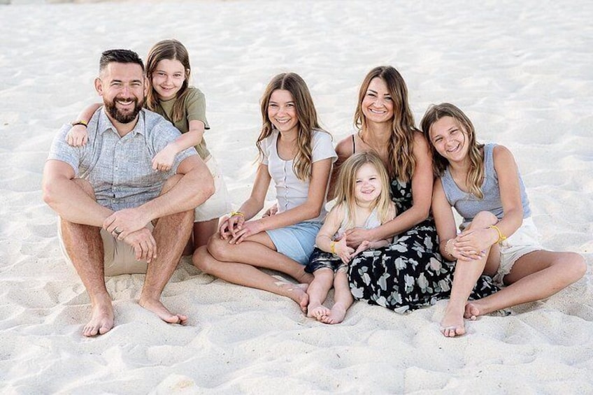 A family of six on a sandy beach. 3