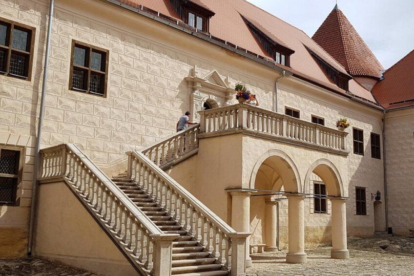 A building with a staircase, arched windows, and a red-tiled roof. 3