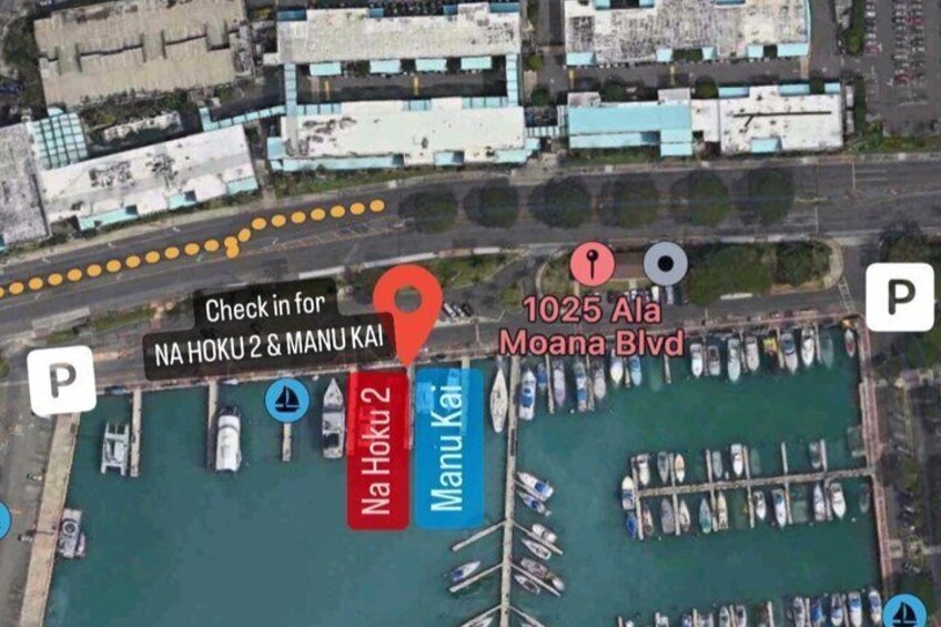 Vista aérea de un puerto deportivo con barcos amarrados, identificado como 'Na Hoku 2 & Manu Kai', y un estacionamiento señalado con una 'P'. 2