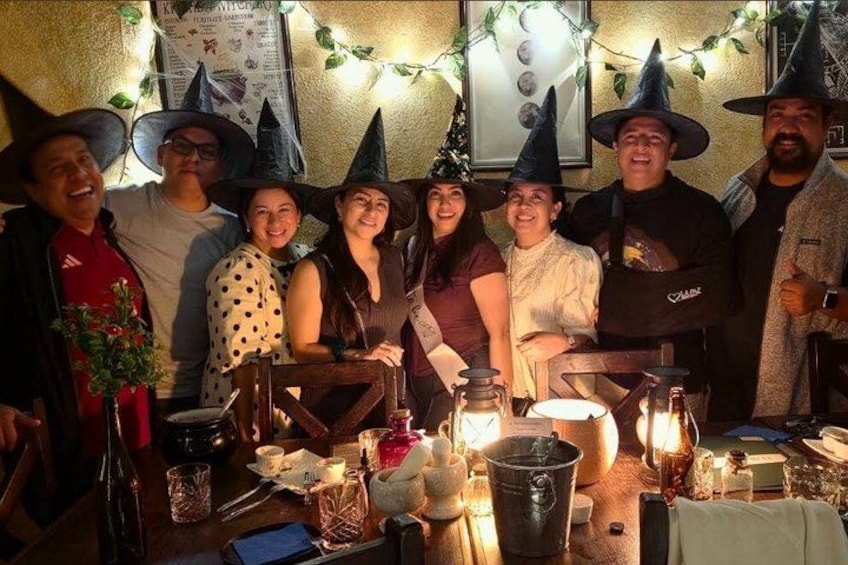 A group of people at a table with a festive atmosphere, decorated with string lights and pumpkins. 1