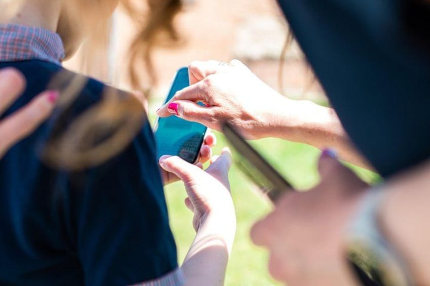 Iemand houdt een smartphone vast en een ander persoon overhandigt een kaart. 4