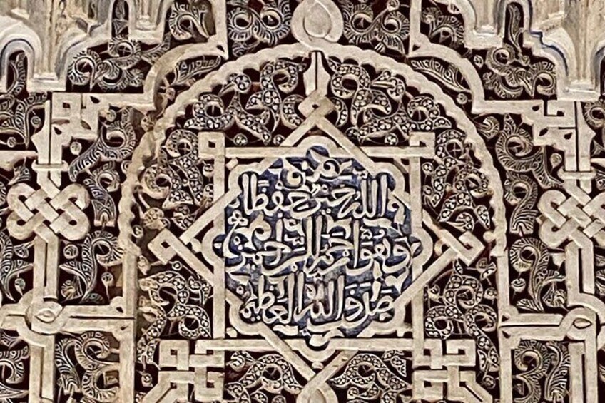 An intricately carved wooden panel with Arabic calligraphy and geometric patterns. 3