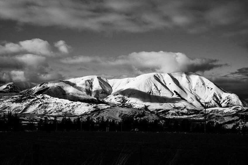 A snow-covered mountain range with a clear sky. 1