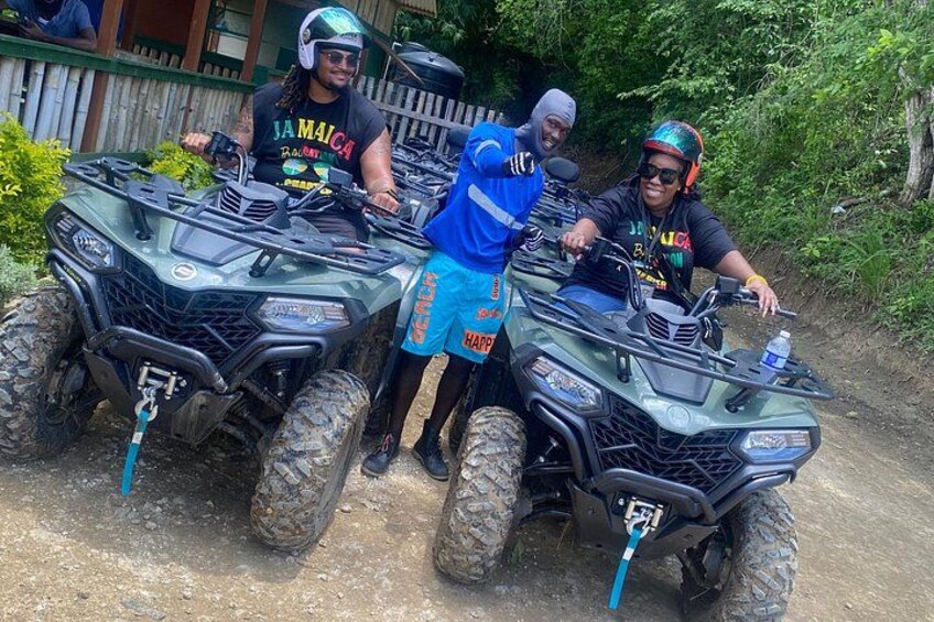 Three people on ATVs, a dirt path, and greenery in the background. 3