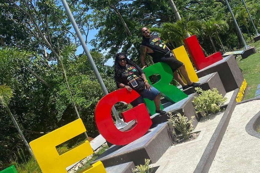 Two people sitting on a structure with large colorful letters spelling 'EGROL.' 2