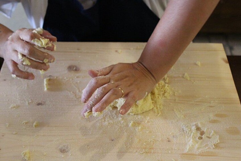 Hands kneading dough on a wooden surface. 3