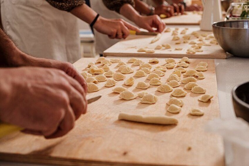 Hands shaping dough on a wooden board. 4