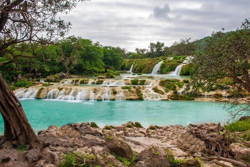 A waterfall cascading over rocky terrain with lush greenery. 3