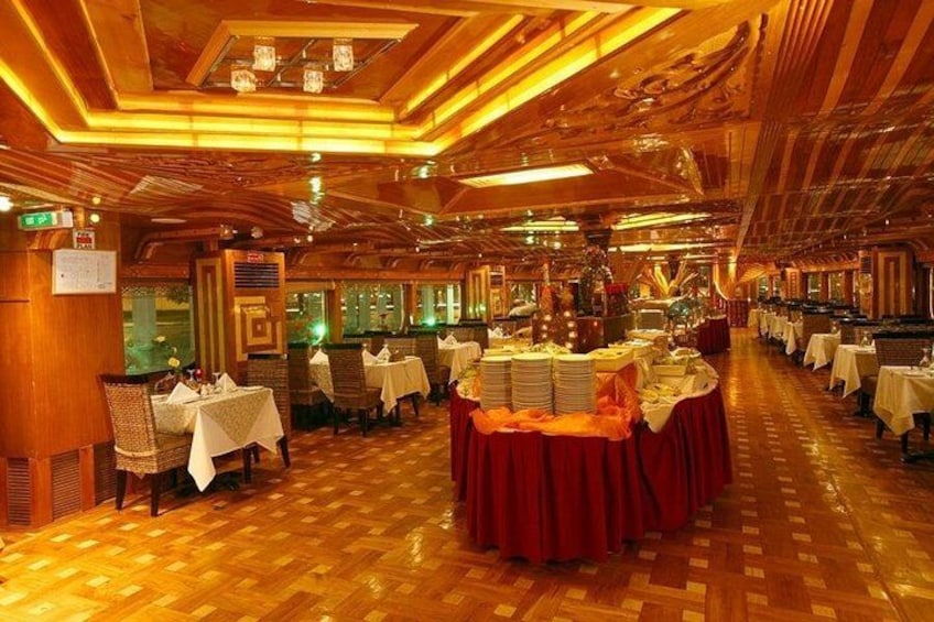 Een restaurant met houten vloeren, tafels met witte tafellinnen en een centrale tafel met een rode tafellaken. 5